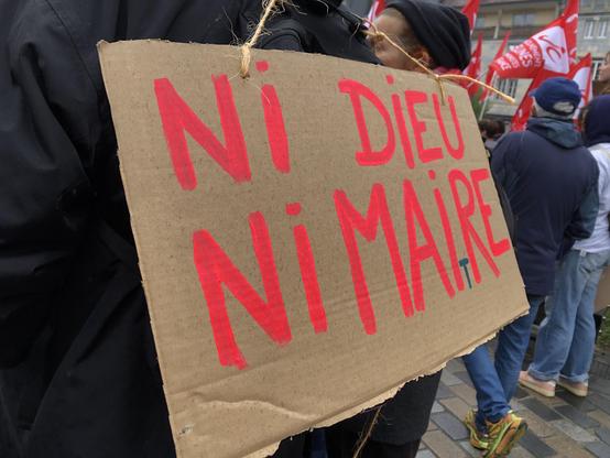 Pancarte de manifestation sur laquelle est écrit : « Ni Dieu, ni Maire »