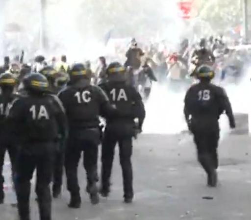 Une image de CRS, reconnaissables aux deux bandes jaunes faisant le tour du casque, avançant vers une foule indistincte, en partie brouillée par de la fumes — et en partie par la faible résolution du cliché.

Dans le dos, chaque CRS pour un chiffre et une lettre, dans l'ordre de gauche à droite : 1A, 1C, 1A, 1B.