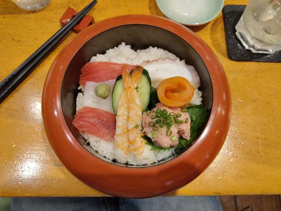 Photo d'un bol de chirashi avec du thon, du saumon, de la crevette, du calamar et du poulpe.