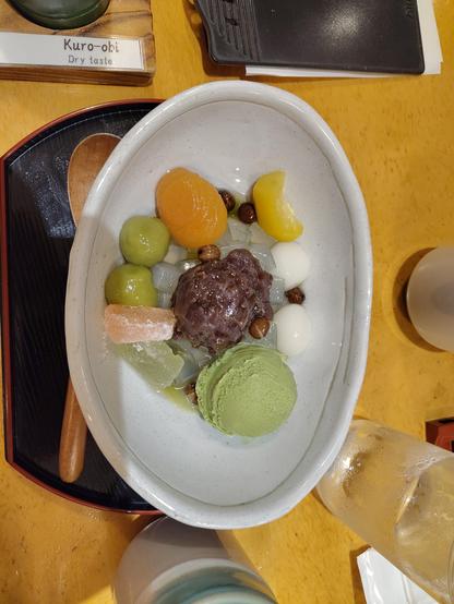 Photo de l'assiette du dessert : une boule de glace au thé vert, une sorte de châtaigne légèrement glacée au sucre, des cubes d'agar-agar, un demi abricot, de la pate d'azuki sucrée et des mini boules de riz gluant