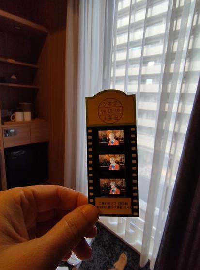 Photo du ticket pour accéder au mini cinéma qui diffuse le court métrage inédit au musée Ghibli. Le ticket est une pellicule avec 3 images d'autres courts inédits insérée dans un papier cartonné estampillé du musée Ghibli.