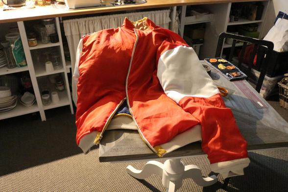 Le blouson retourné sur sa doublure blanche et rouge, proprement rabattue à la main.