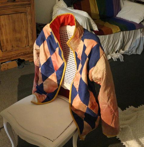 le même blouson posé sur une chaise, de sorte qu'on aperçoit la doublure rouge du col.