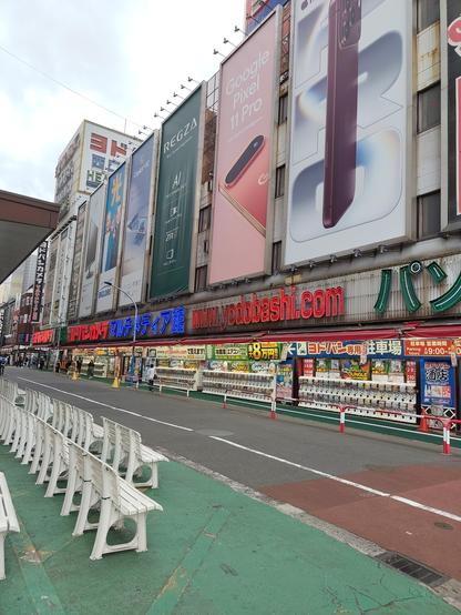 Photo du quartier Akihabara avec toutes les façades d'une rue recouvertes d'énormes panneaux publicitaires.