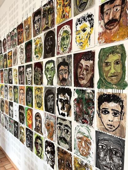 visages peints accrochés au mur