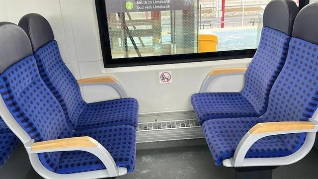 Seats on a light rail train, facing each other