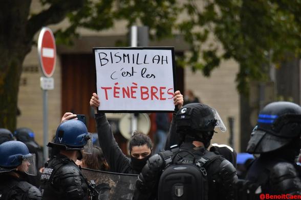pancarte Bismillah c'est les ténèbres brandie devant les policiers