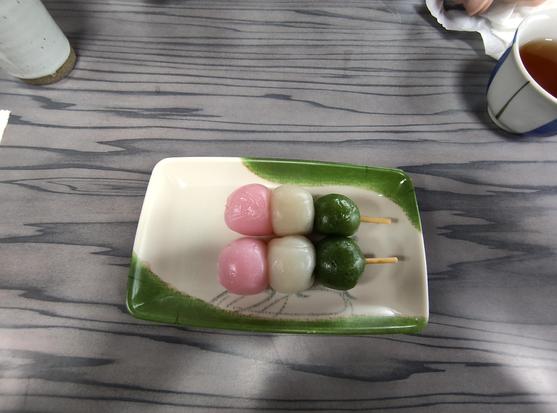 Photo d'un dessert de type dango : ce sont 2 brochettes de 3 boulettes de riz gluant sucré chacune. Une boule verte, une blanche, une rose. C'est le reflet exact de l'emoji dango, justement.